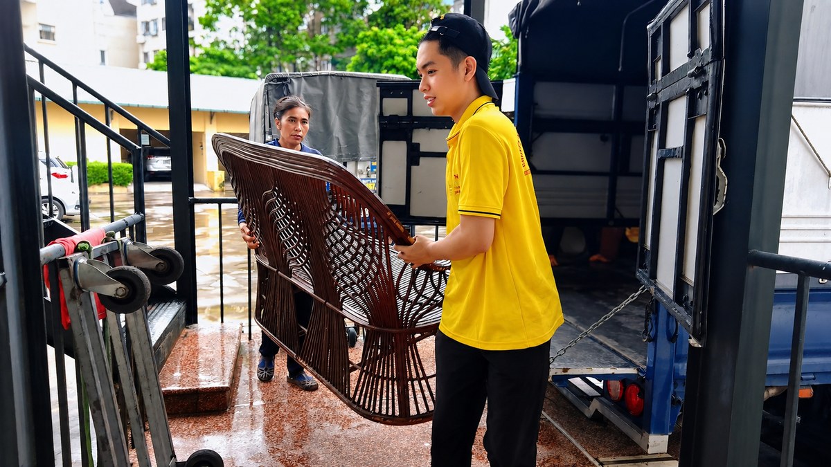 Nhân viên di chuyển ghế mây trong quá trình chuyển đồ